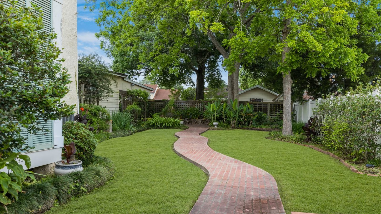 The gardens of The Caldwell House beneath the century oaks