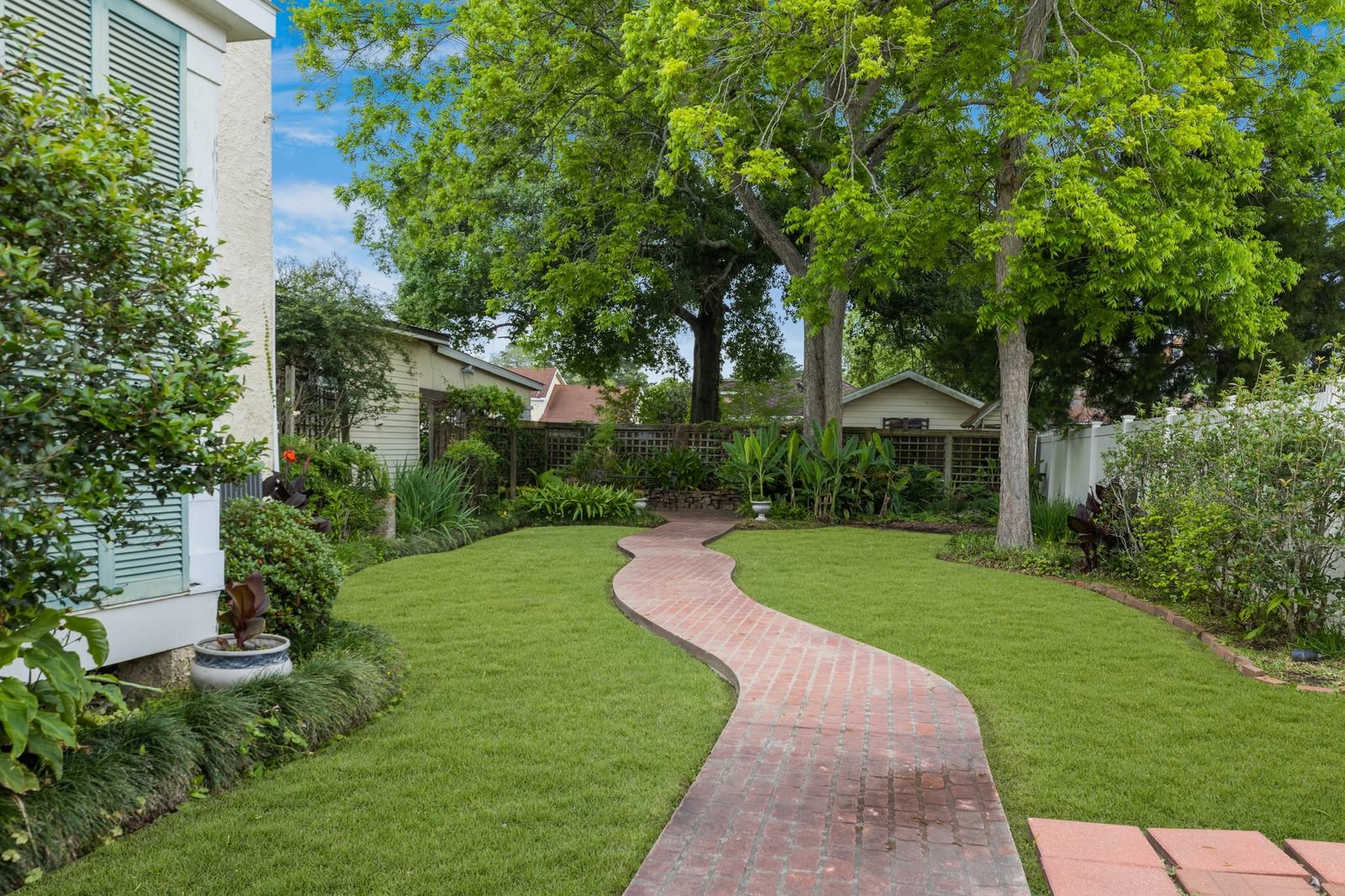 The East Garden at The Caldwell House — brick path and oaks in the afternoon light