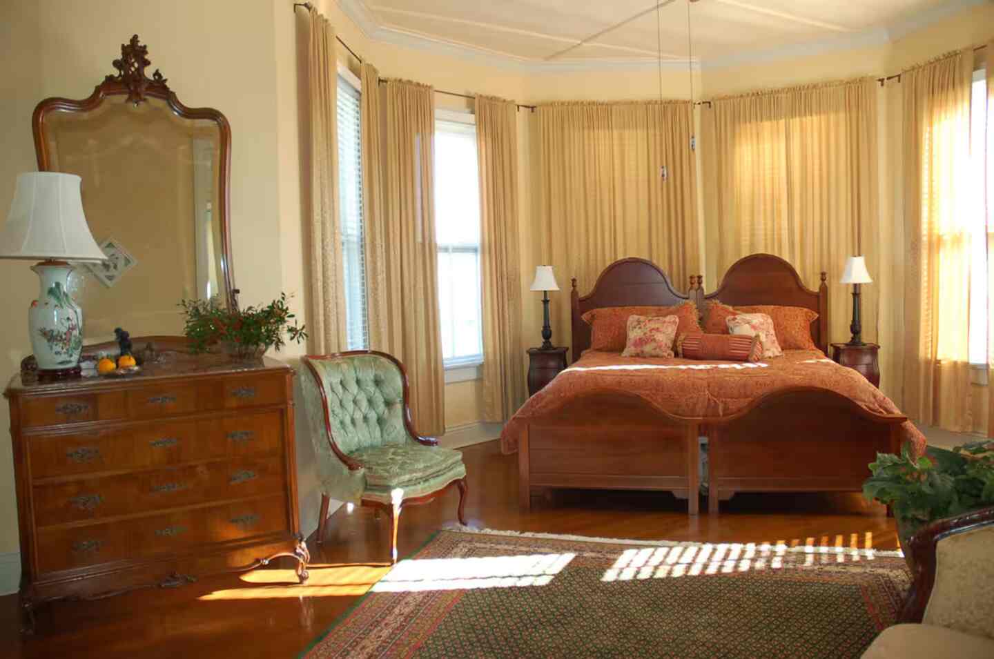 A guest room's antique sitting area with a caned settee and vintage furnishings