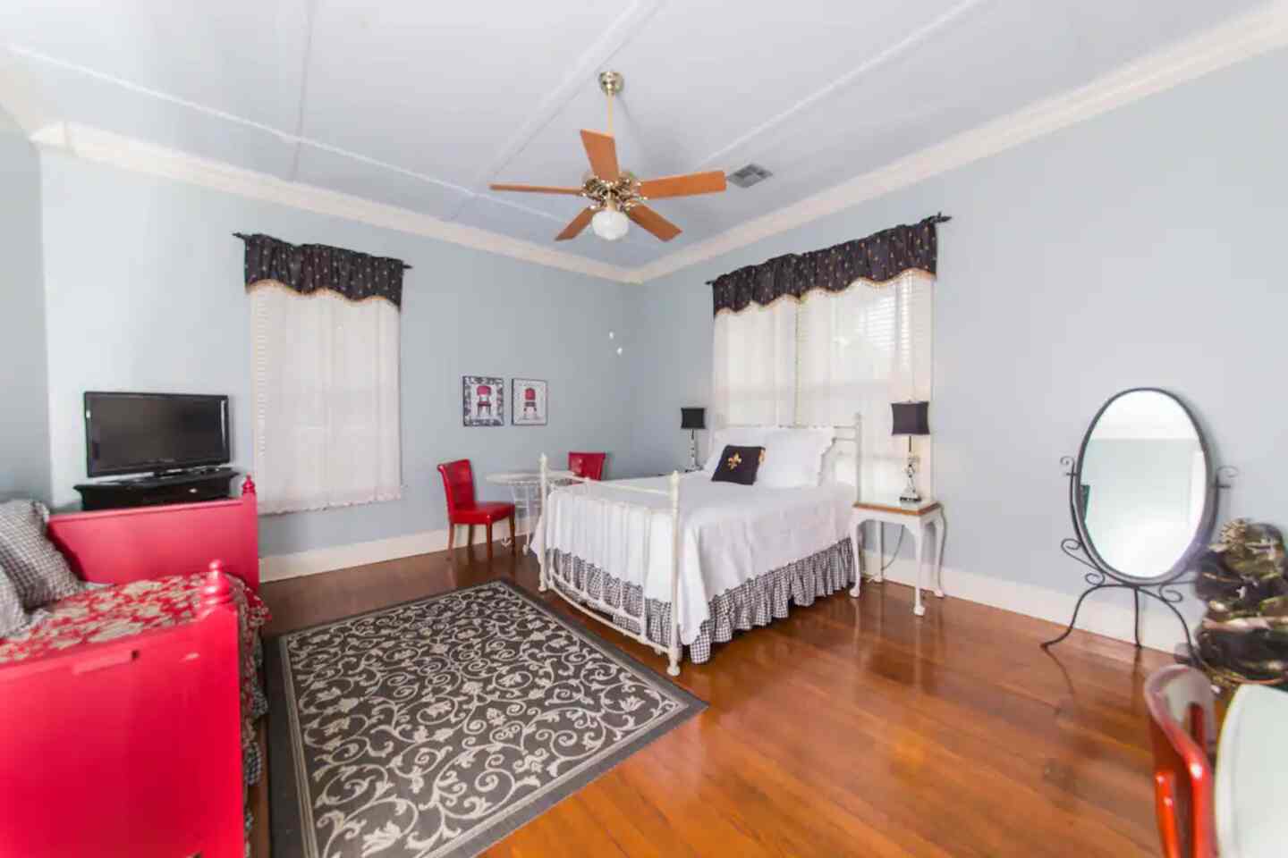 A guest room with an ornate iron bed and floral linens