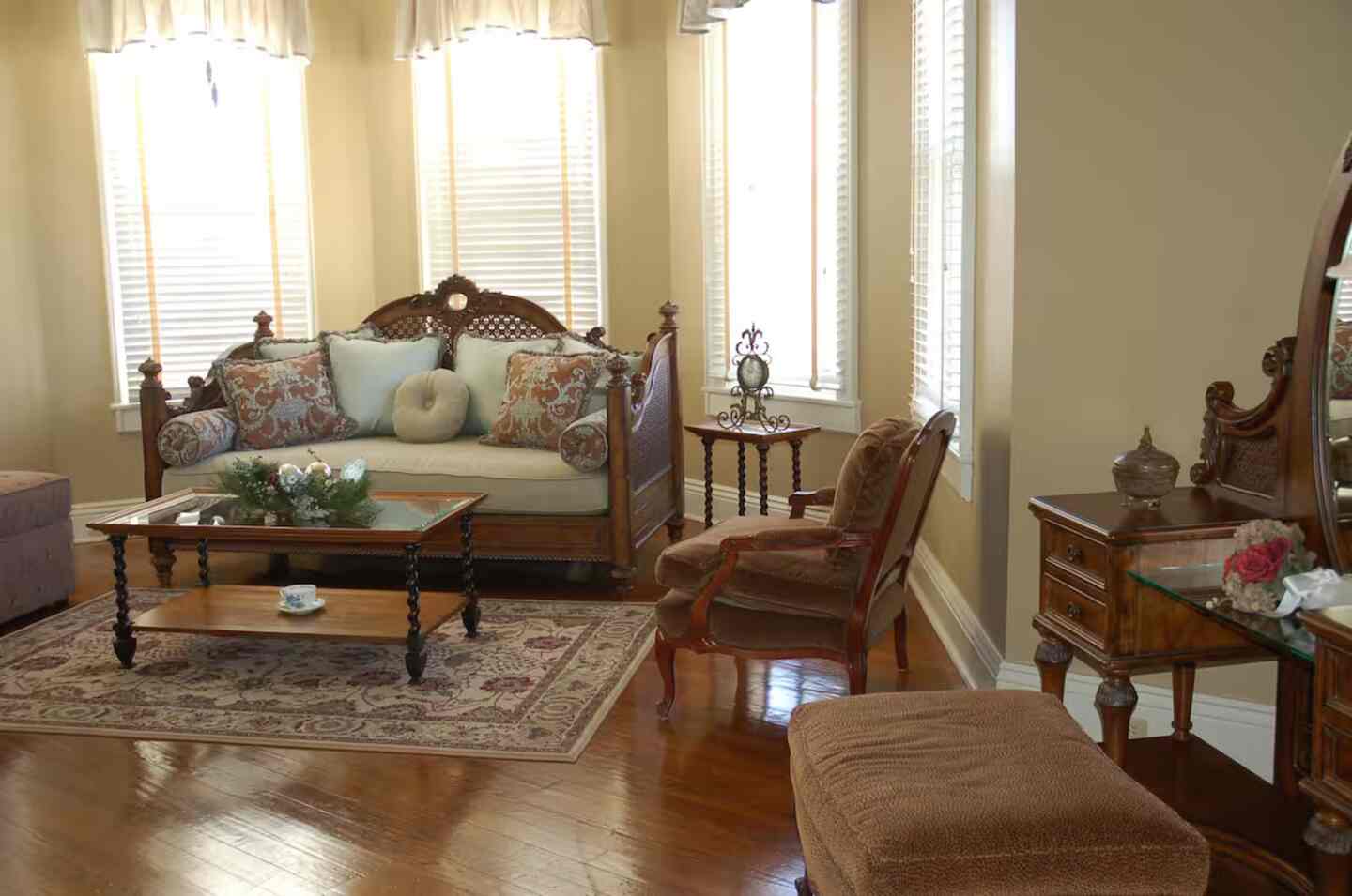 A guest room with a grand carved bed beneath a pressed-tin ceiling